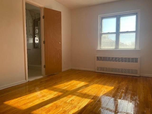 spare room with light hardwood / wood-style flooring and radiator heating unit