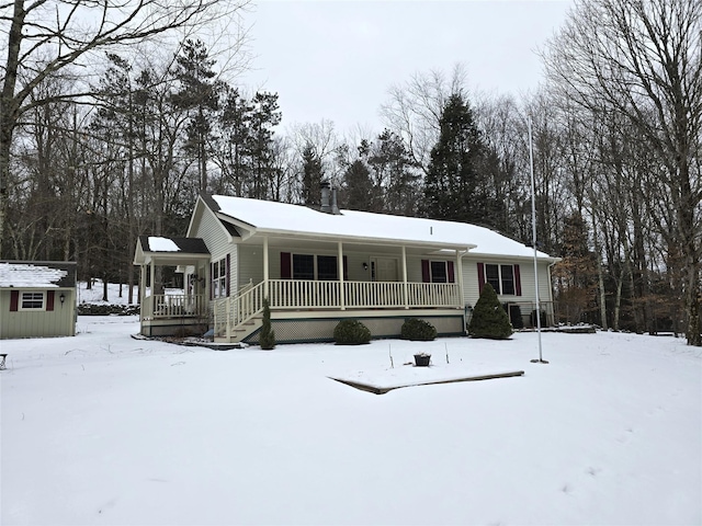 view of front of house featuring covered porch and a shed