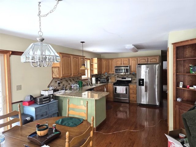 kitchen with hanging light fixtures, kitchen peninsula, tasteful backsplash, and stainless steel appliances