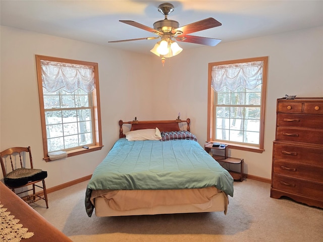 carpeted bedroom featuring ceiling fan and multiple windows