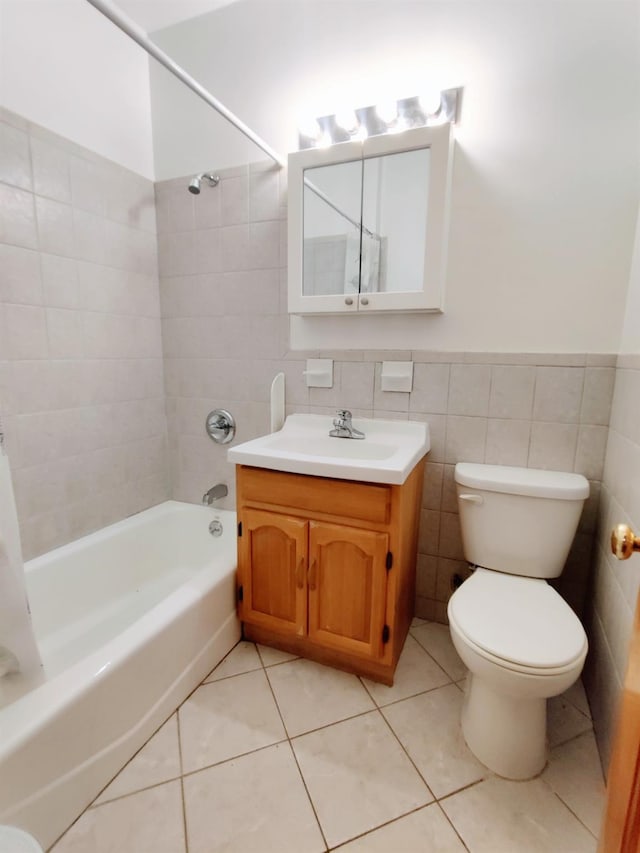 full bathroom featuring tiled shower / bath, tile patterned floors, vanity, tile walls, and toilet