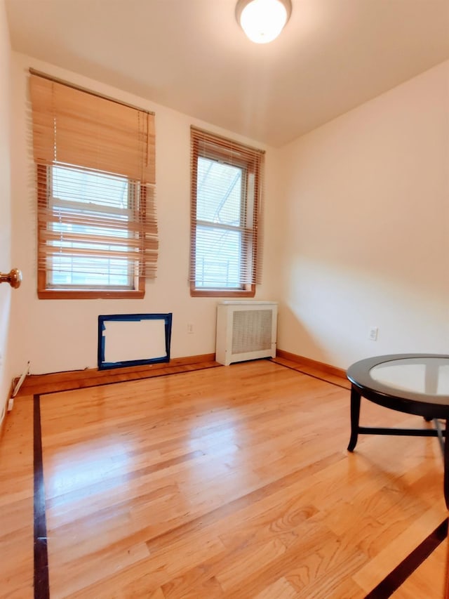 unfurnished room with hardwood / wood-style flooring and radiator