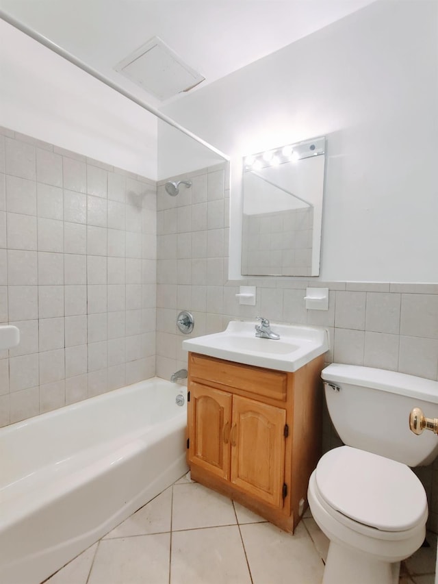 full bathroom with toilet, vanity, tile walls, tiled shower / bath, and tile patterned floors