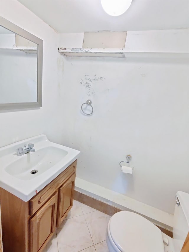 bathroom with toilet, vanity, and tile patterned floors