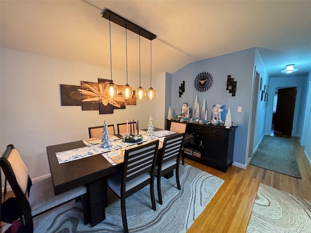 dining space featuring lofted ceiling and light hardwood / wood-style floors