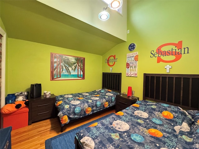 bedroom with wood-type flooring and vaulted ceiling