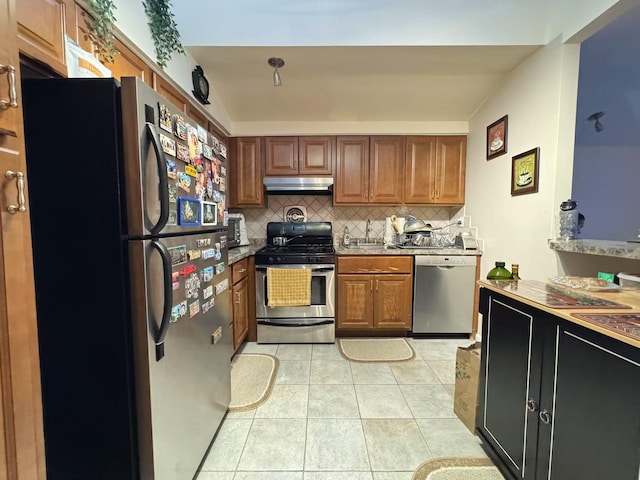 kitchen with tasteful backsplash, light tile patterned floors, and appliances with stainless steel finishes