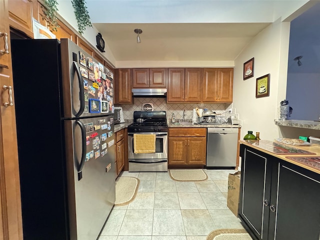 kitchen with backsplash, light tile patterned floors, and stainless steel appliances