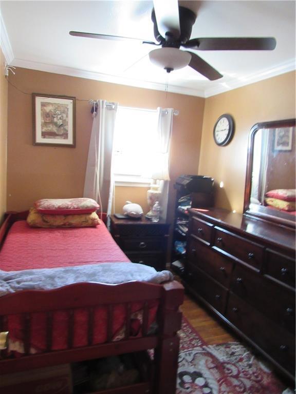 bedroom featuring ceiling fan, ornamental molding, and hardwood / wood-style flooring