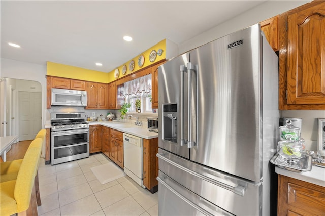 kitchen featuring light tile patterned floors, stainless steel appliances, and sink