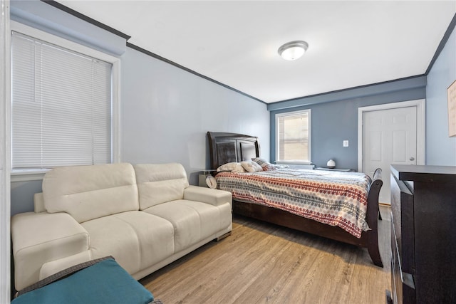 bedroom featuring ornamental molding and light hardwood / wood-style flooring