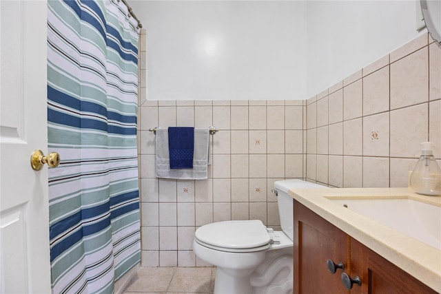 bathroom with toilet, tile walls, tile patterned floors, walk in shower, and vanity