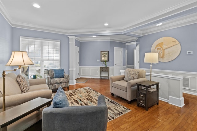 living room featuring ornate columns, crown molding, and hardwood / wood-style floors