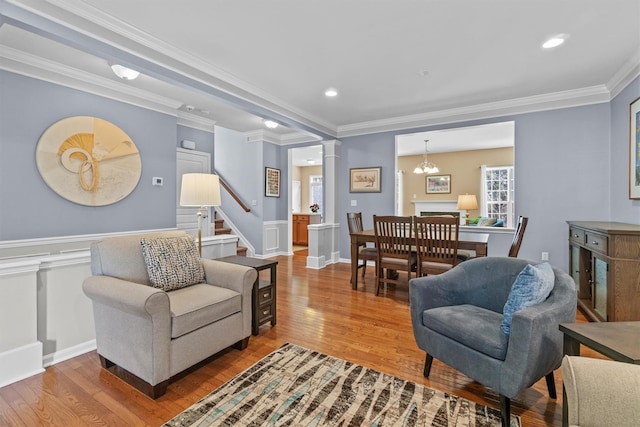 living room with wood-type flooring, ornamental molding, and ornate columns