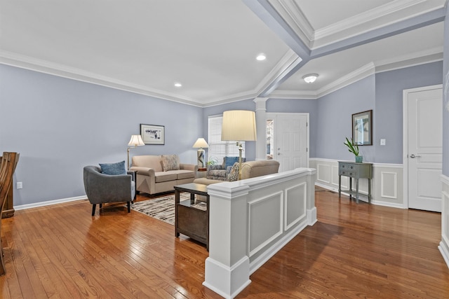 living room featuring hardwood / wood-style flooring, ornamental molding, and decorative columns