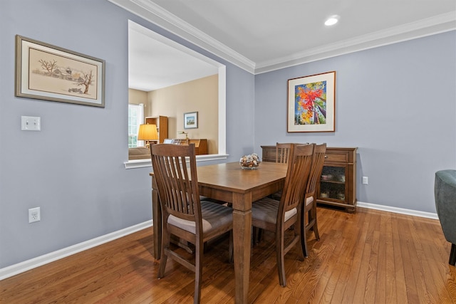 dining area featuring crown molding and hardwood / wood-style floors