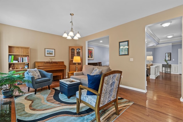 living room featuring wood-type flooring, crown molding, an inviting chandelier, beam ceiling, and coffered ceiling