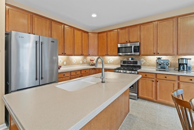 kitchen featuring decorative backsplash, appliances with stainless steel finishes, and a kitchen island with sink