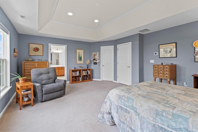 bedroom with carpet, a raised ceiling, and ensuite bath