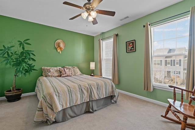 carpeted bedroom featuring ceiling fan and multiple windows