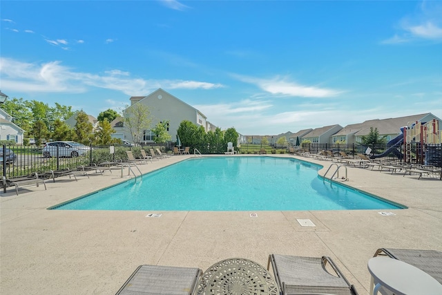 view of swimming pool with a playground and a patio area