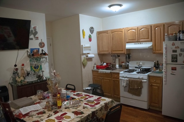 kitchen featuring dark hardwood / wood-style floors, tasteful backsplash, and white appliances