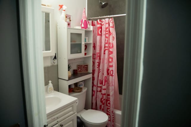 full bathroom with shower / bath combo with shower curtain, toilet, and vanity