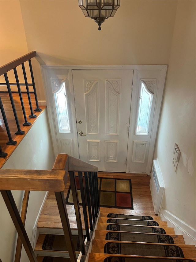 entryway featuring baseboard heating, wood-type flooring, and a wall mounted air conditioner