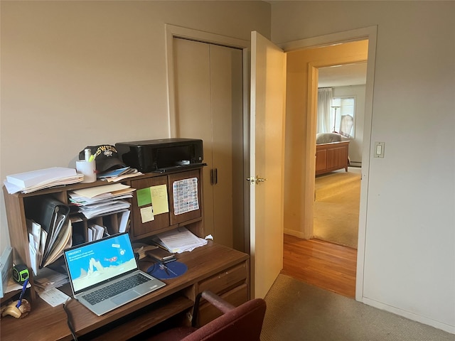 carpeted office featuring baseboard heating