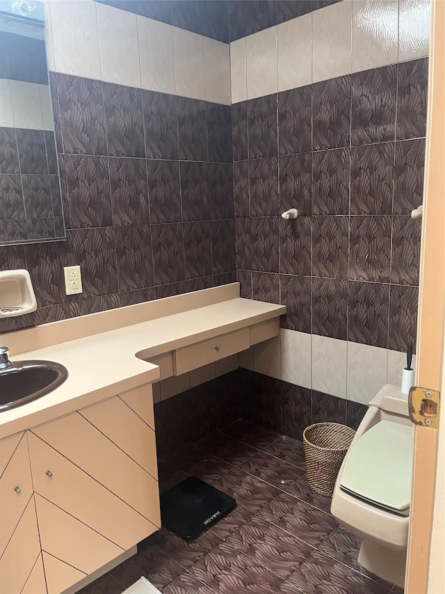 bathroom with toilet, tile walls, and vanity