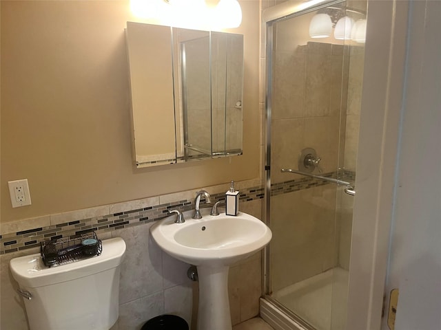 bathroom with a shower with door and toilet