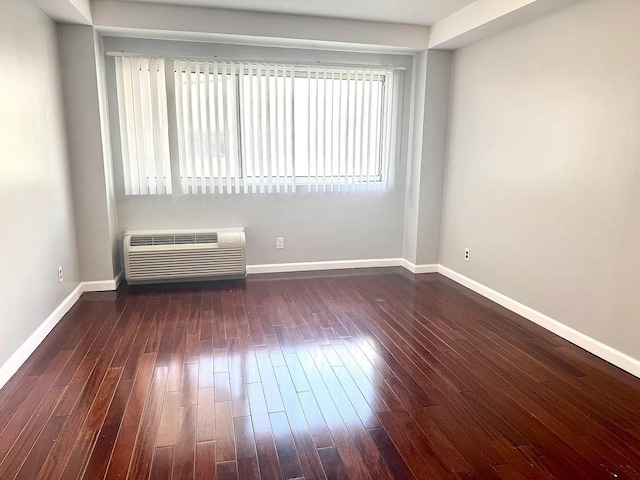 spare room with dark hardwood / wood-style flooring and a wall mounted air conditioner