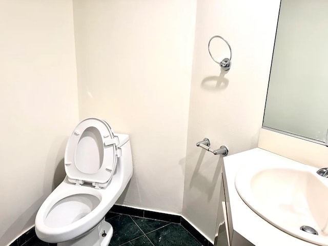 bathroom featuring toilet, vanity, and tile patterned flooring