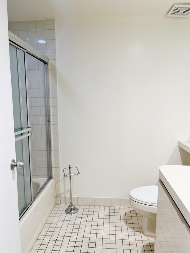 full bathroom featuring toilet, bath / shower combo with glass door, tile patterned flooring, and vanity