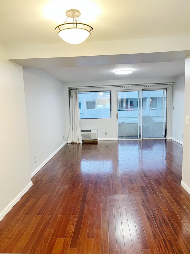 unfurnished room with dark wood-type flooring and a wall mounted AC