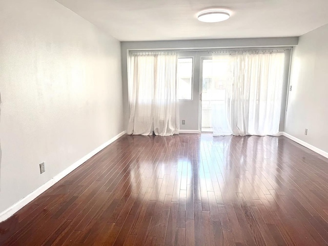 empty room with dark hardwood / wood-style flooring