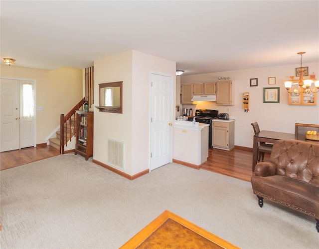 carpeted living room featuring an inviting chandelier