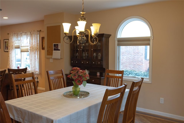 dining area with dark hardwood / wood-style floors and a chandelier