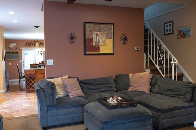 living room with a wall mounted air conditioner and a notable chandelier