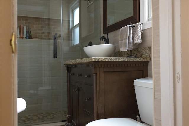 bathroom featuring decorative backsplash, toilet, vanity, and an enclosed shower