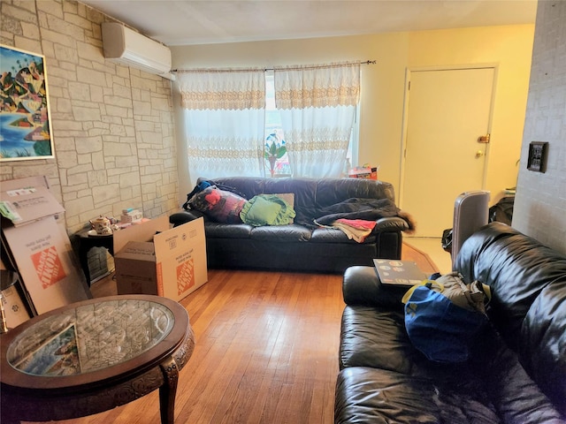 living room with a wall mounted air conditioner and light hardwood / wood-style flooring