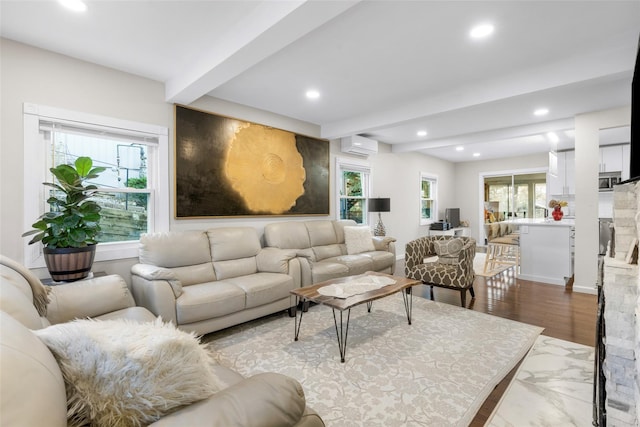 living room featuring a wealth of natural light, an AC wall unit, beam ceiling, and wood-type flooring