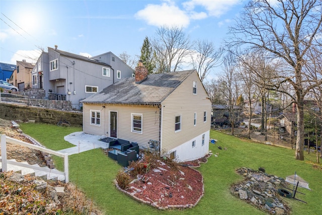 back of property featuring a lawn, an outdoor hangout area, and a patio