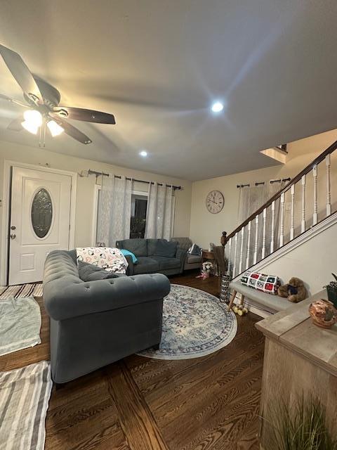 living room featuring ceiling fan and dark wood-type flooring