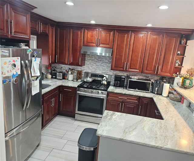 kitchen featuring light stone countertops, decorative backsplash, appliances with stainless steel finishes, and kitchen peninsula