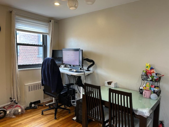 home office featuring hardwood / wood-style flooring and radiator heating unit