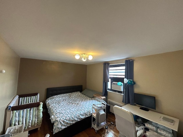 bedroom with wood-type flooring and radiator heating unit