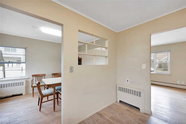 interior space featuring radiator, ornamental molding, light hardwood / wood-style flooring, and a baseboard radiator