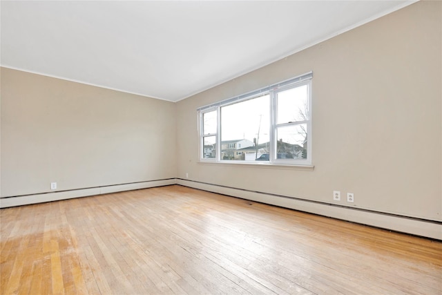 unfurnished room featuring a baseboard radiator and light hardwood / wood-style flooring