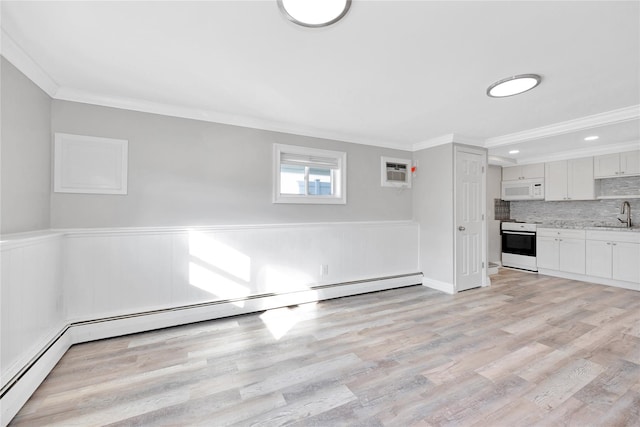 interior space with a wall mounted air conditioner, ornamental molding, light hardwood / wood-style flooring, and sink